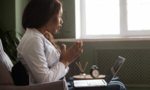 woman conducting telemed psychiatric services on her laptop