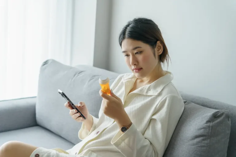 Woman looking at a prescription bottle after asking "Can an online psychiatrist prescribe medication?"