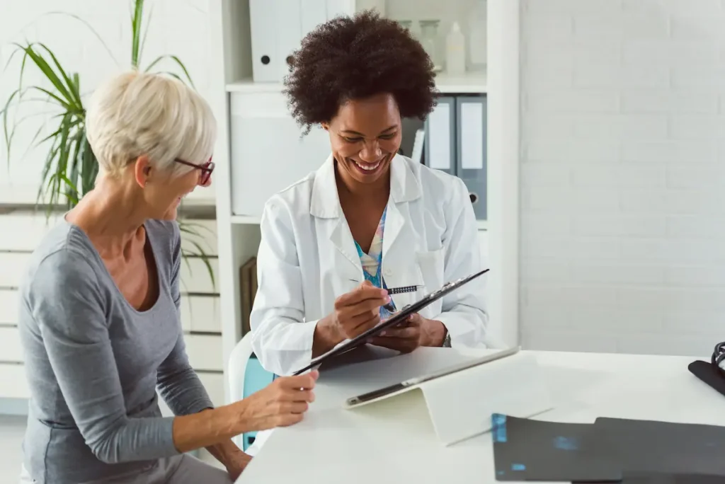 Primary care provider with patient reviewing health chart as part of integrated services for behavioral health