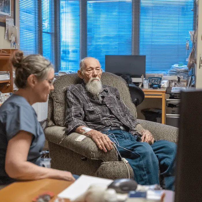 Elderly man in a senior care facility with his nurse taking part in mental health session