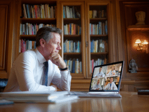A doctor is in his office on a video conference.