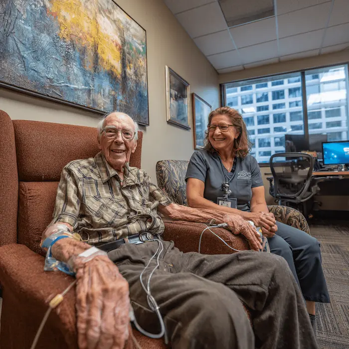 Nursing home resident with his caretaker, learning about virtual geriatric psychiatry